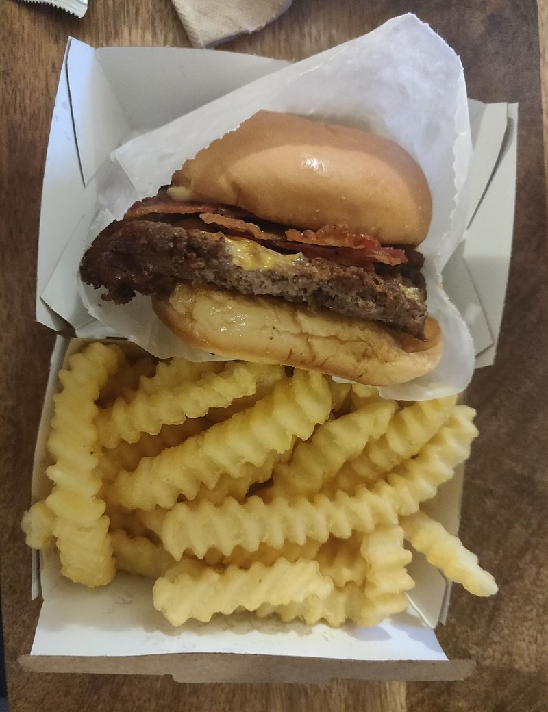Un cheeseburger et des frites servis dans une barquette